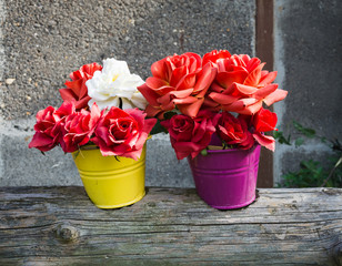 two flowerpots with artificial roses