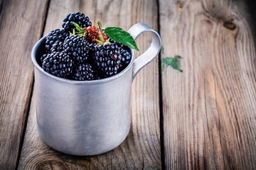 Fototapeta na wymiar juicy fresh organic blackberries in old mug