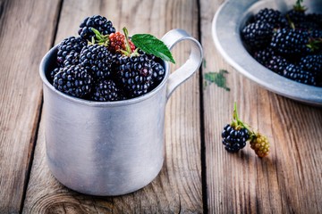Fototapeta na wymiar juicy fresh organic blackberries in old mug