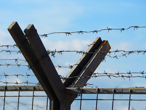 fence with barbed wire against the sky
