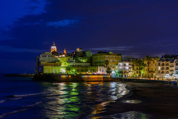 Fototapeta na wymiar Sitges, Spain - June 10: Illuminated sea shore and buildings on