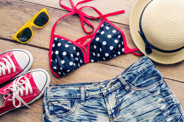 Fototapeta premium Beauty colorful bikini and accessories on wooden floor