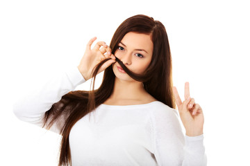 Funny student woman putting hair like moustache