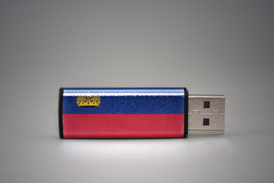 usb flash drive with the national flag of liechtenstein on gray background.
