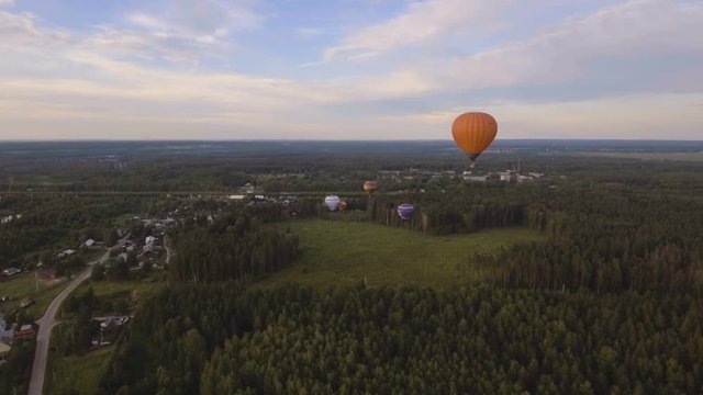 Hot air balloon in the sky over a field in the countryside.Aerial view:Hot air balloon in the sky over a field in the countryside in the beautiful sky and sunset.Aerostat fly in the countryside. 4K