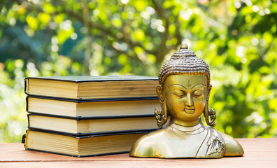 Buddha statue and stack of old books. Spa concept. Education concept. Calmness and tranquility....