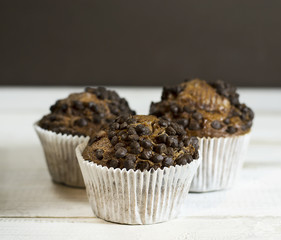 Chocolate cupcake on an old white wooden background.