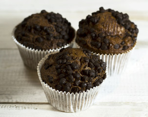 Chocolate cupcake on an old white wooden background.