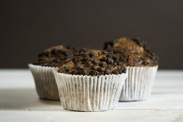 Chocolate cupcake on an old white wooden background.