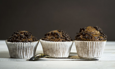 Chocolate cupcake on an old white wooden background.