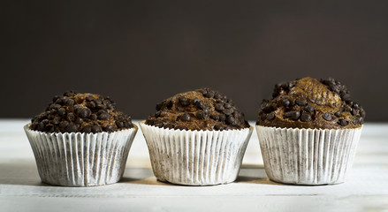 Chocolate cupcake on an old white wooden background.