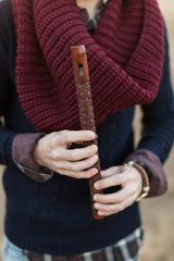wooden flute in the man's hands.