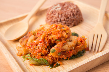 Brown rice with spicy paste stir fried with fish  in wooden dish