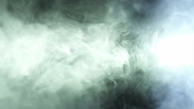 The stream of thick smoke on a dark background. Slow motion capture