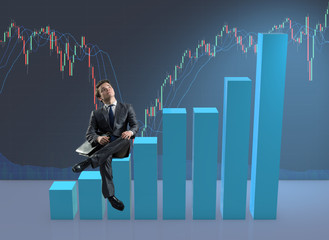 Businessman sitting on bar charts in business concept