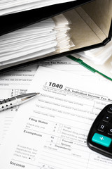 Close up U.S. Individual tax form 1040 with calculator and pen.