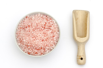 wooden scoop, bowl full of bath salts with pink and white grains