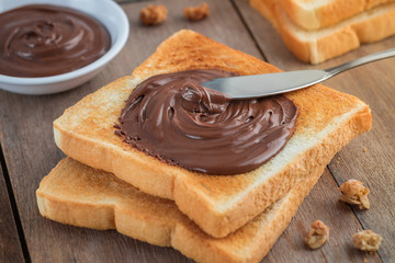 Bread with chocolate cream on wooden table