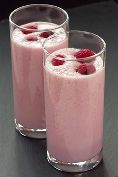 Raspberry milkshake drink / Delicious fresh raspberry milkshake or yogurt on dark background