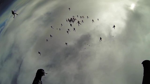 Skydivers falling in grey sky. Making huge formation. Extreme. Height. Cloudness sky