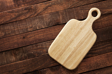 Cutting board on a wooden table, top view