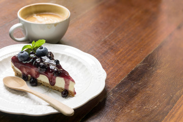 Blue berry cheese cake and coffee latte on wooden desk