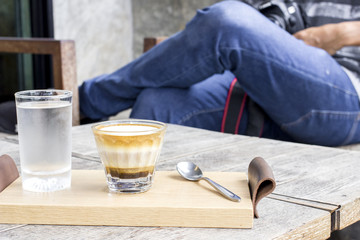 Man sitting in coffee shop with cappuccino coffee cup on table