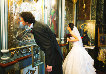 Bride and groom kissing altar wall - obrazy, fototapety, plakaty