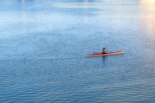 A young woman kayaking on a river or sea, sports and recreation.