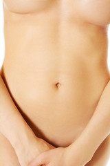 Attractive nude woman covering herself