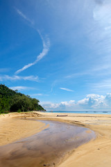 Small river flows into the sea in sunny day with just some cloud