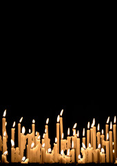 Yellow wax church candels burning in the dark. Copy space for text