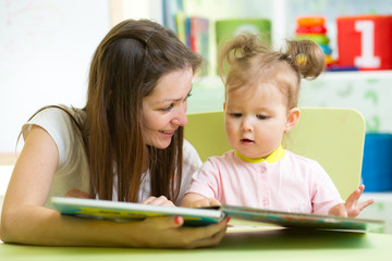 Happy mother and daughter reading a book together