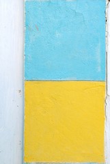 White wall with yellow and blue paint squares