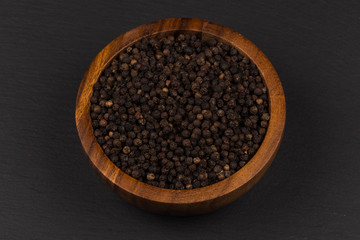 Black pepper in wooden bowl