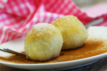 Sweet plum  dumplings sprinkled with sugar and cinnamon, closeup
