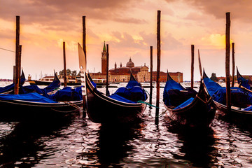 Saint Giorgio Maggiore Church in sunset, view from San Marco embankment. The church with a tower on the island and gondola in the foreground . Venice, Italy. Beautiful sunset sky in the background.