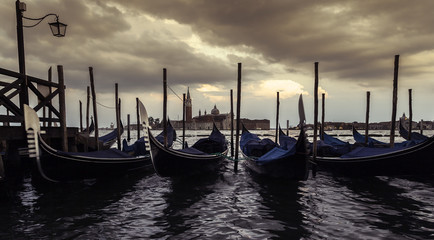 Fototapeta premium Saint Giorgio Maggiore Church in sunset, view from San Marco embankment. The church with a tower on the island and gondola in the foreground . Venice, Italy. Beautiful sunset sky in the background.
