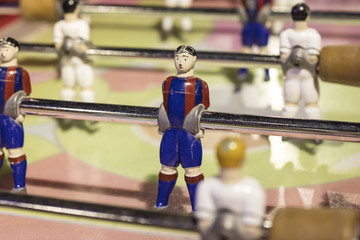 Detail of table football players, painted in red and blue stripes
