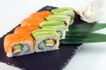 Red and green sushi on the black stone Salmon sushi and avocado sushi on black slate close up 