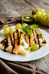 Pancakes with mascarpone filling, kiwi, grape and chocolate topping