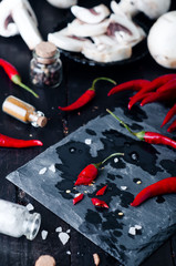Slicing Chilli pepper with Knife on kitchen board