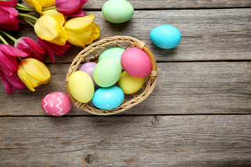 Easter eggs with tulips on a grey wooden table