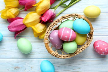 Obraz na płótnie Canvas Easter eggs with tulips on a blue wooden table