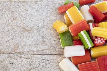 Colorful gummy jellies and sweets on a wooden table