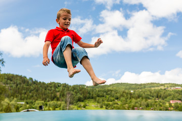 Young boy jumping on bouncing pillow