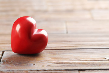 Red heart on brown wooden table