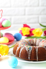 Easter eggs with cake on a white wooden table