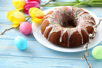 Easter eggs with cake on a blue wooden table