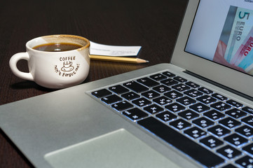 Laptop and coffee cup on wood table